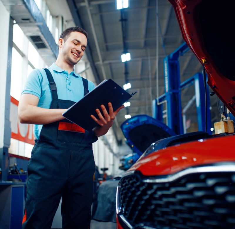 Worker with a checklist, car service station